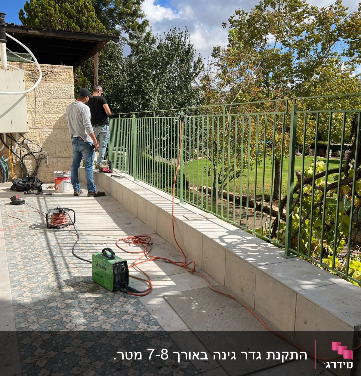 שני אנשים עובדים ליד מעקה ירוק עם כבלים וכלים